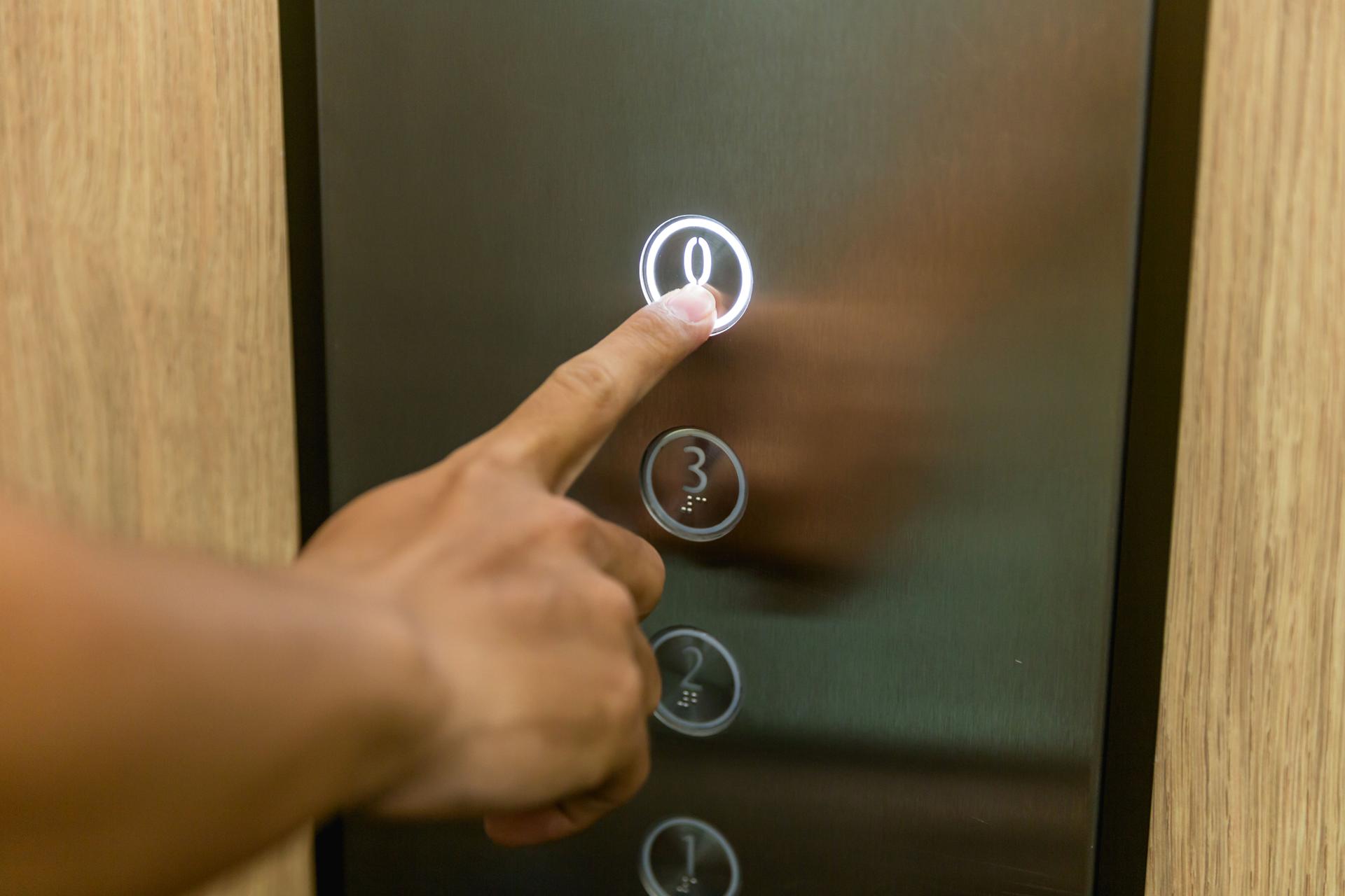 Adult men pressing elevator button